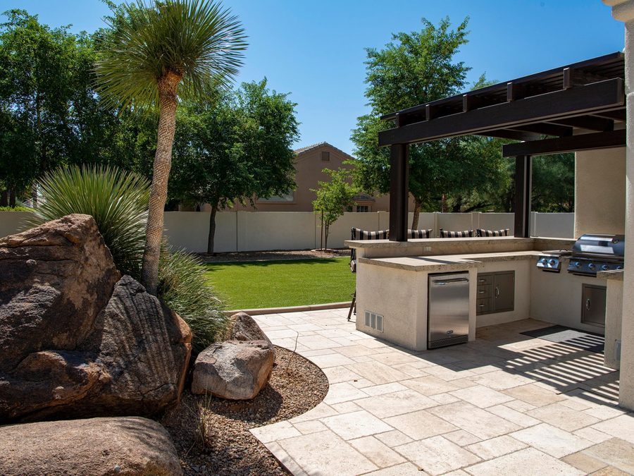 A pool deck with stepping stones set into lawn beside a covered terrace